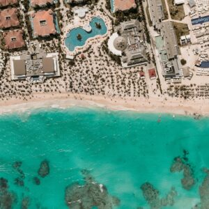 Stunning aerial view of a resort by turquoise waters and sandy beach.