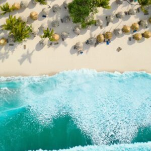 Stunning aerial shot of a tropical beach with turquoise waves and palm trees in the Dominican Republic.