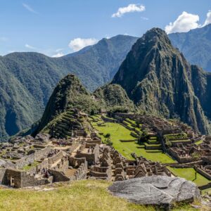 Aerial view of the iconic Machu Picchu ruins surrounded by lush green mountains in Peru.